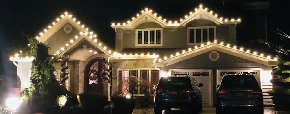 Craftsman home with warm white lights on every roofline