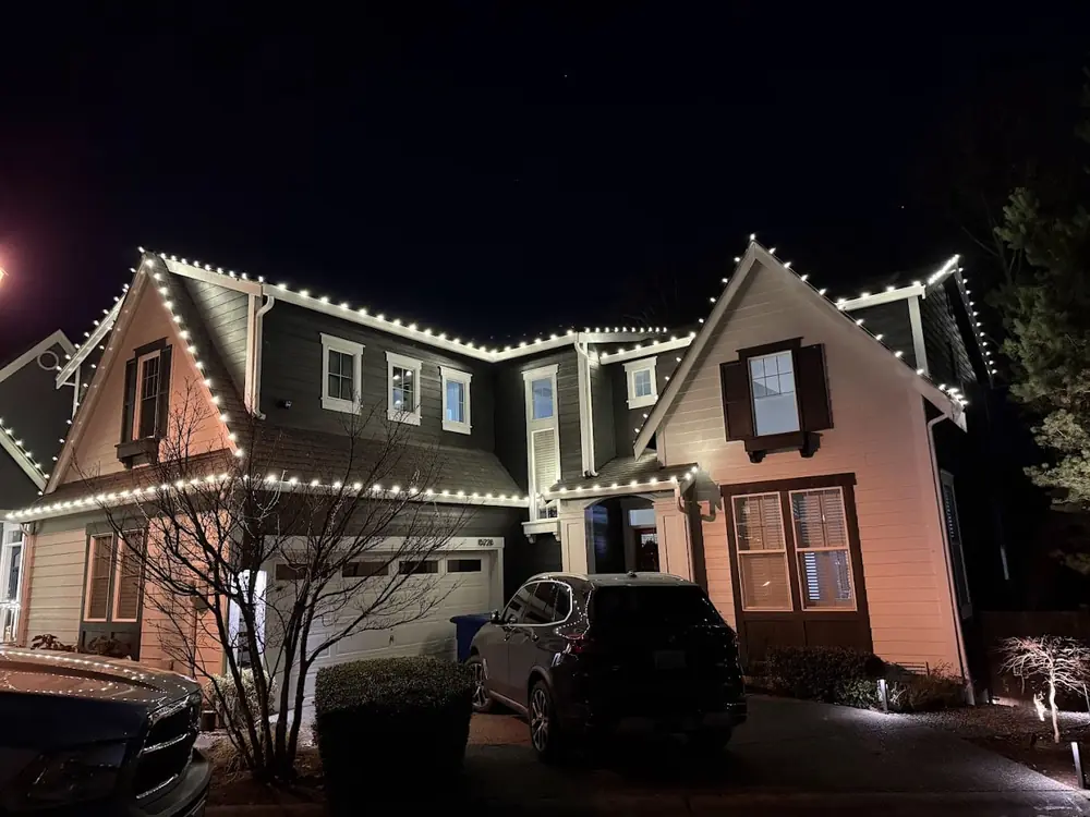 Two story home with warm white roofline and gable lights